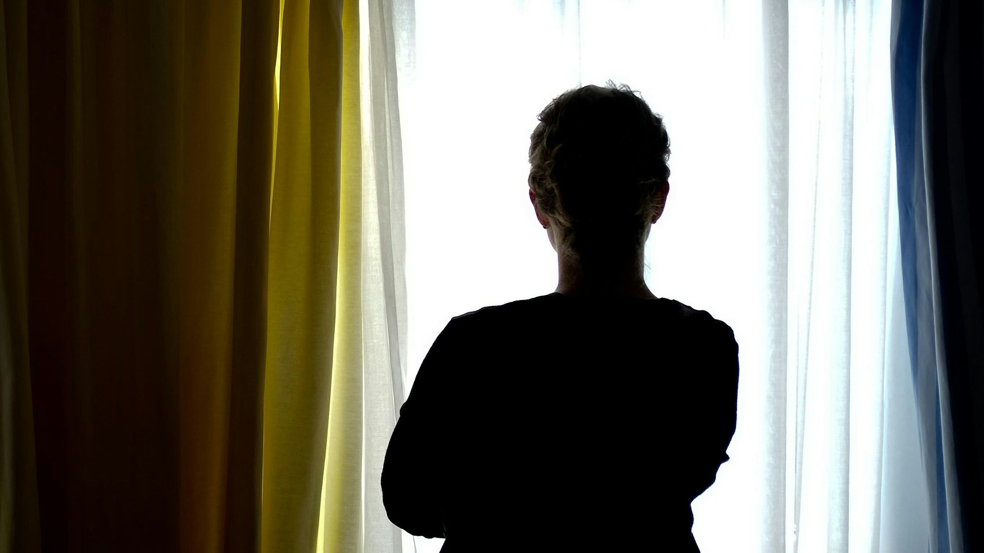 Das Bild zeigt eine junge Frau in einem Zimmer eines Frauenhauses.Foto: Peter Steffen/dpa