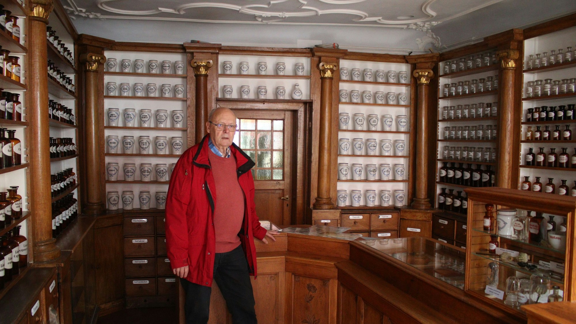 Günter Kirchner lehnt am Verkaufstisch. Er steht in der Offizin des Apothekenmuseums in Bad Münstereifel, die wieder komplett eingerichtet ist.