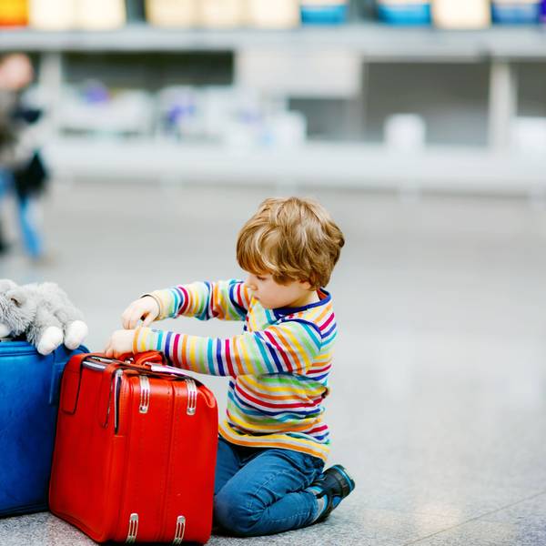 Ein Junge mit Koffern am Flughafen.