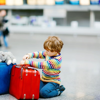 Ein Junge mit Koffern am Flughafen.