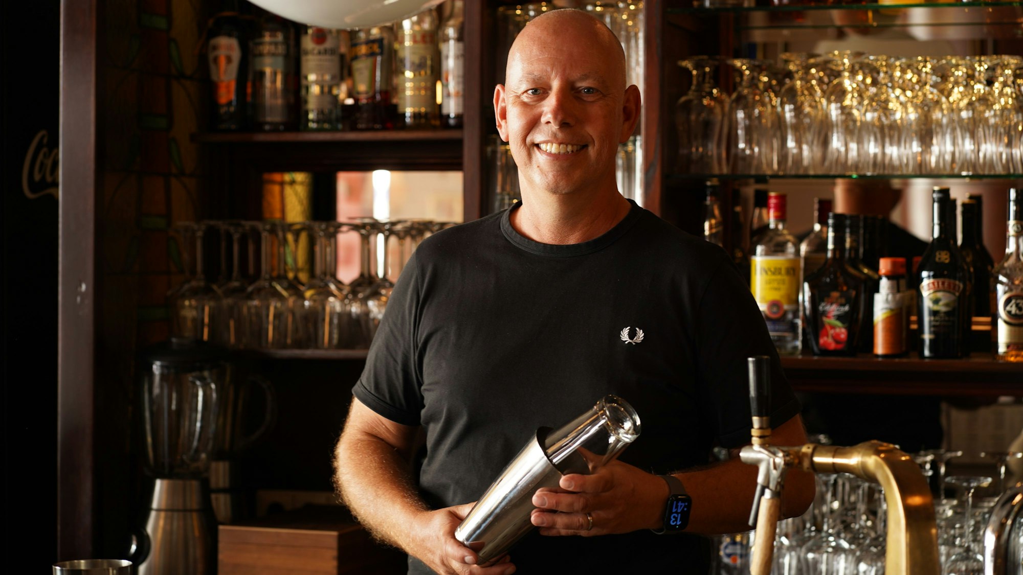 Das Foto zeigt einen Mann hinter einer Bartheke.