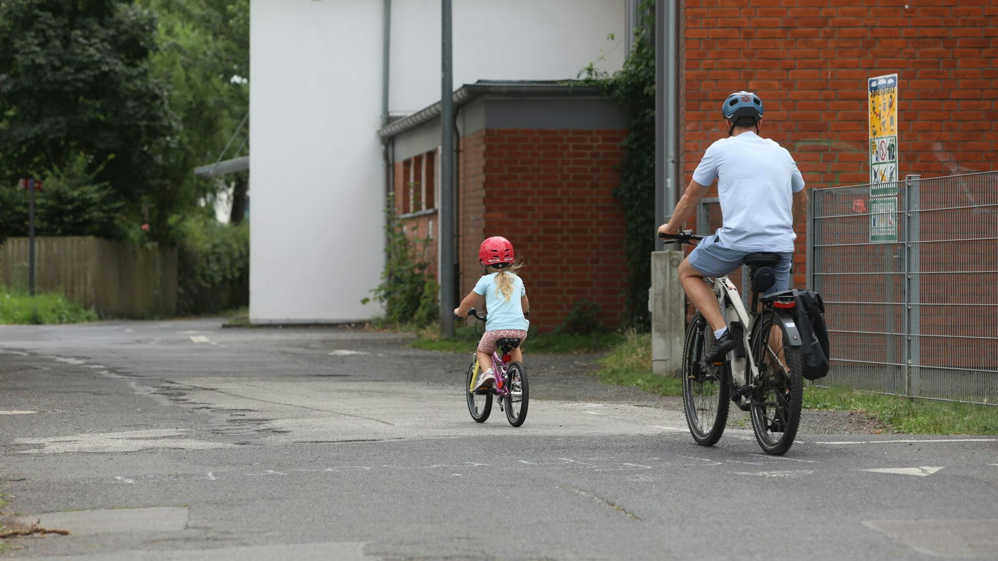 Ein Vater und ein Kind fahren auf Fahrrädern.