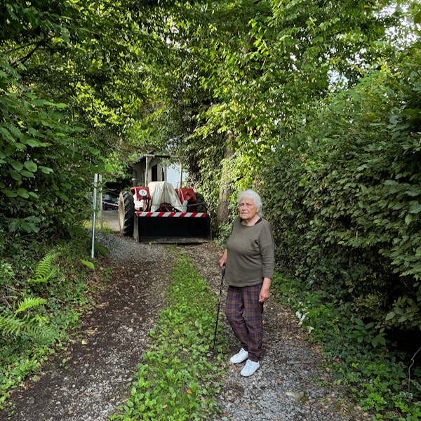 Irmintraut Fuchs vor der Eisenkette und dem Trecker, die ihr den Weg zu ihrem Grundstück versperren.