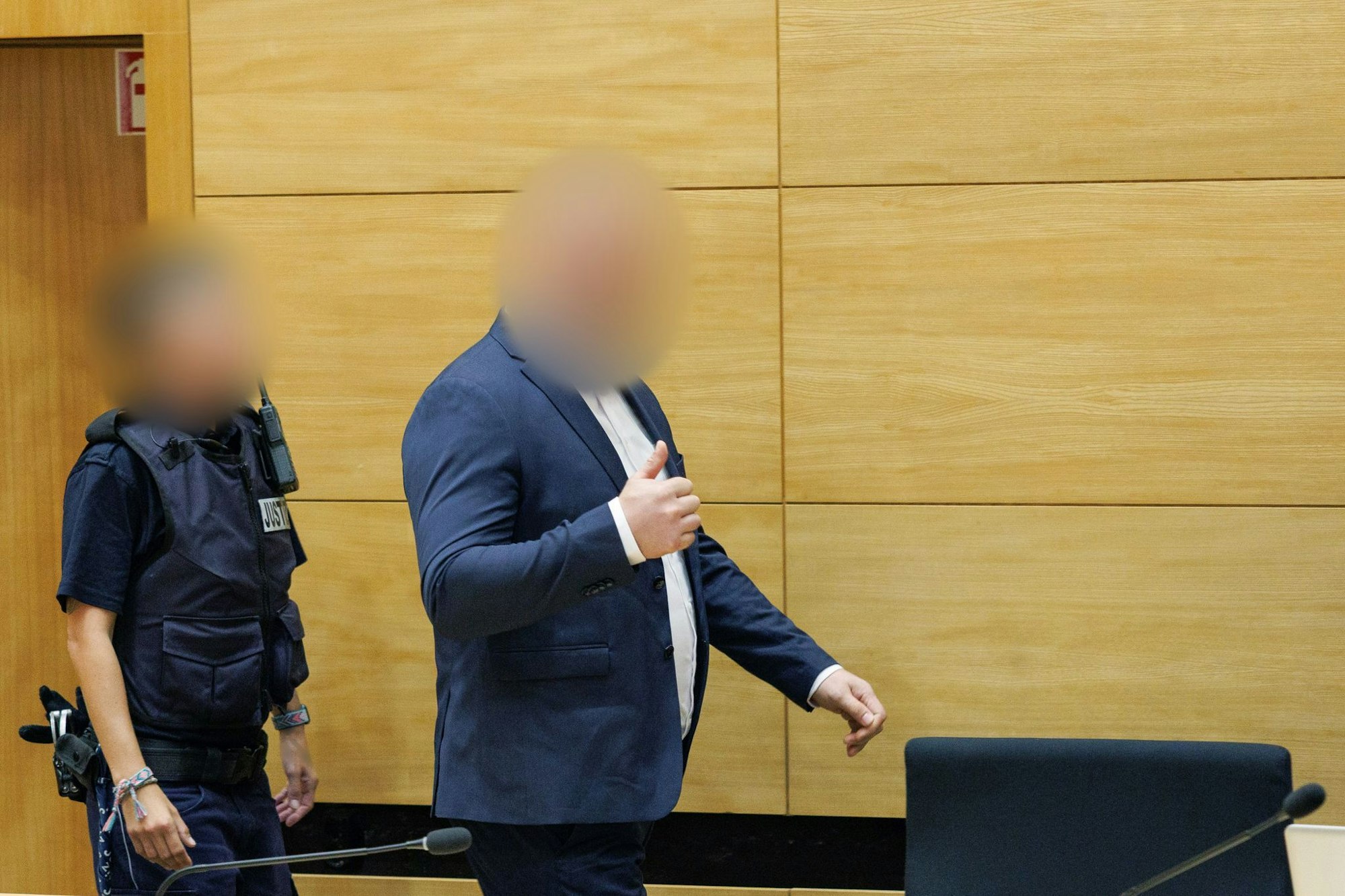 Der Angeklagte zeigt mit dem Daumen nach oben beim Eintritt in den Saal am Landgericht Bielefeld.