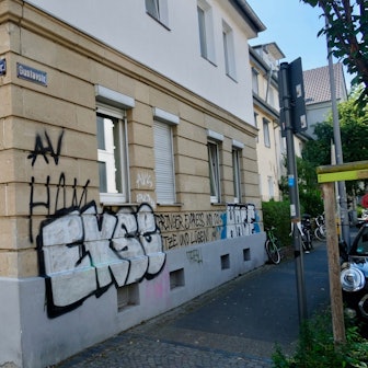 Eine Häuserecke ist mit großen Buchstaben besprüht.
