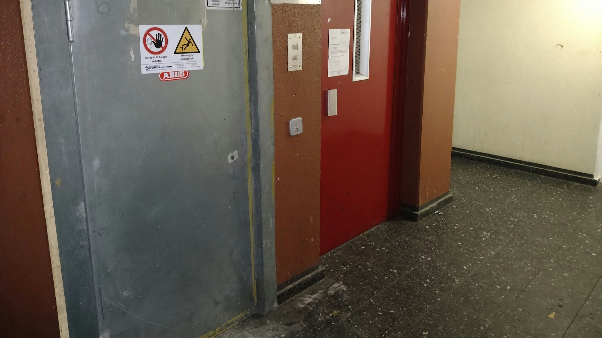 Zwei Aufzugtüren in einem schmucklosen Treppenhaus sind zu sehen.