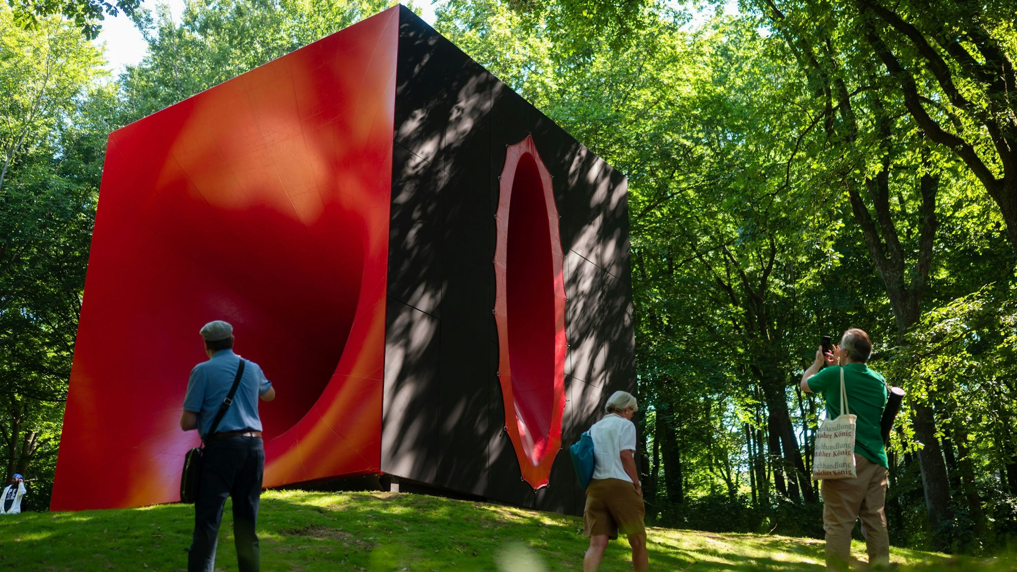 11.08.2022, Nordrhein-Westfalen, Wuppertal: Besucher stehen im Skulpturenpark Waldfrieden vor der Großskulptur.