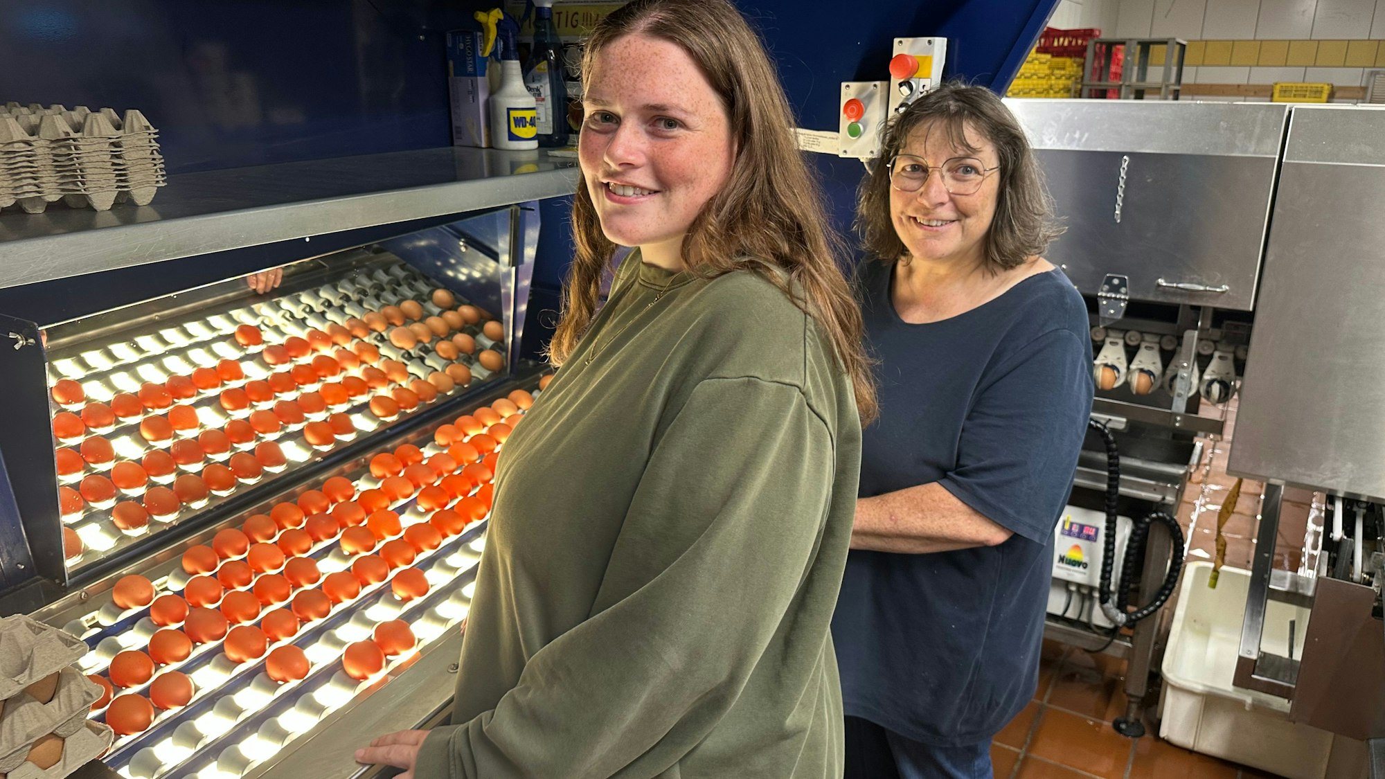 Anna Telohe (links) mit ihrer Mutter Astrid, geborene Wirtz. Beide kontrollieren an einem Lichttisch frisch gelegte Eier auf Bruchstellen.