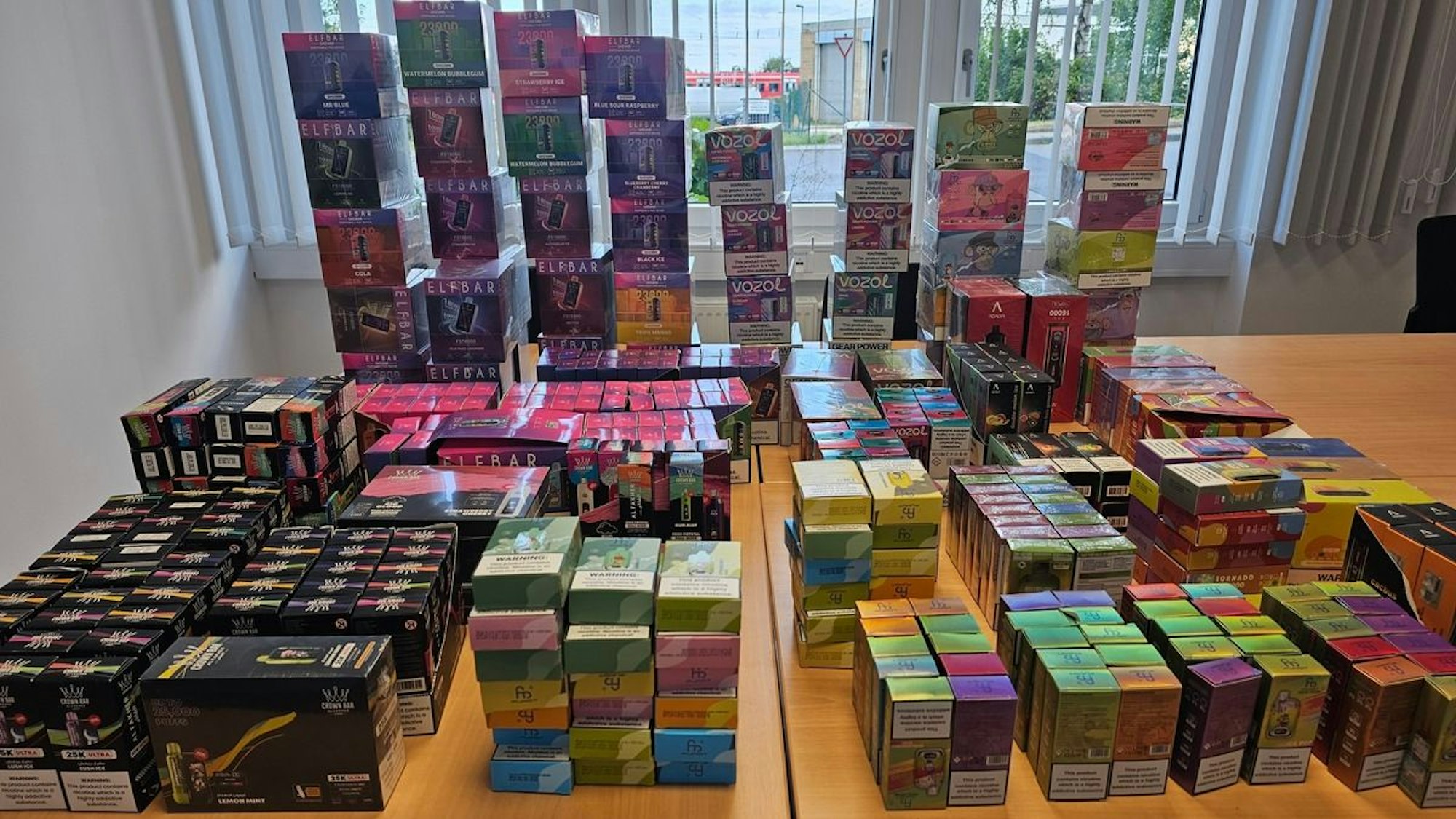 Die vom Zoll sichergestellten illegalen Vapes und der Wasserpfeifentabak liegen auf einem Tisch.