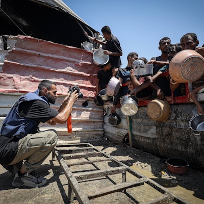 Anas Zeyad Fteha fotografiert Menschen vor einer Essensausgabe im Gaza-Streifen