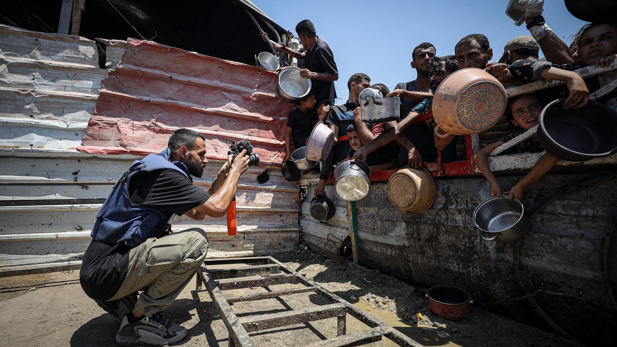 Anas Zeyad Fteha fotografiert Menschen vor einer Essensausgabe im Gaza-Streifen.
