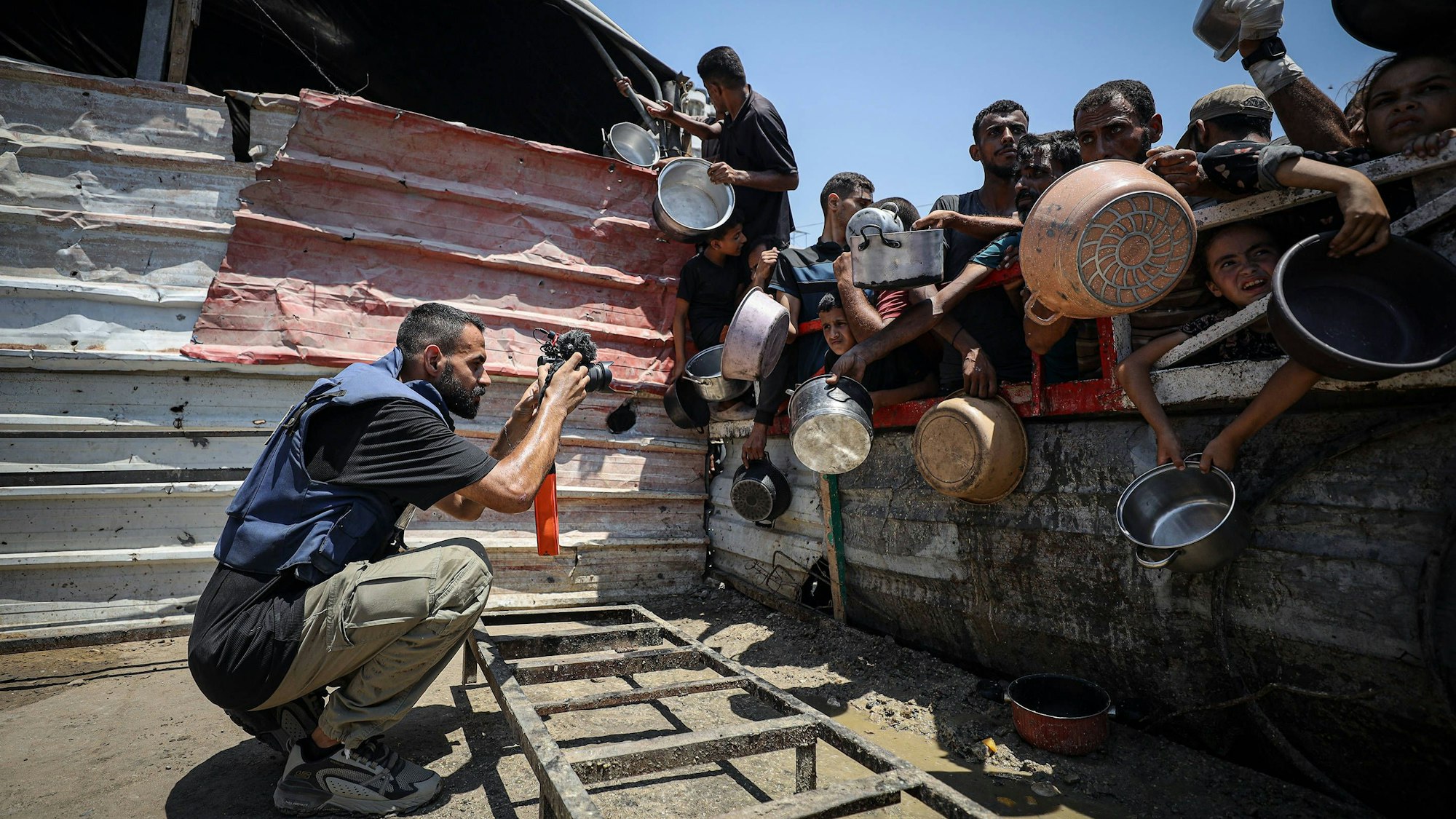 Anas Zeyad Fteha fotografiert Menschen vor einer Essensausgabe im Gaza-Streifen.