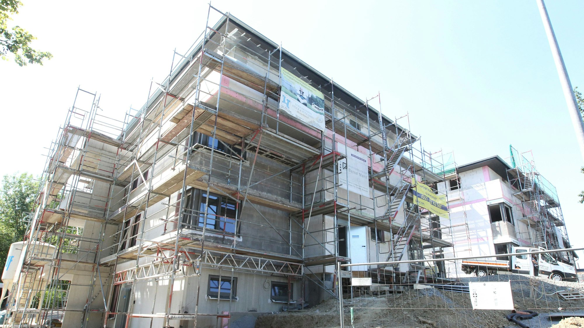 Ein Haus in Much wird gebaut und ist von allen Seiten von einem Gerüst umschlossen.