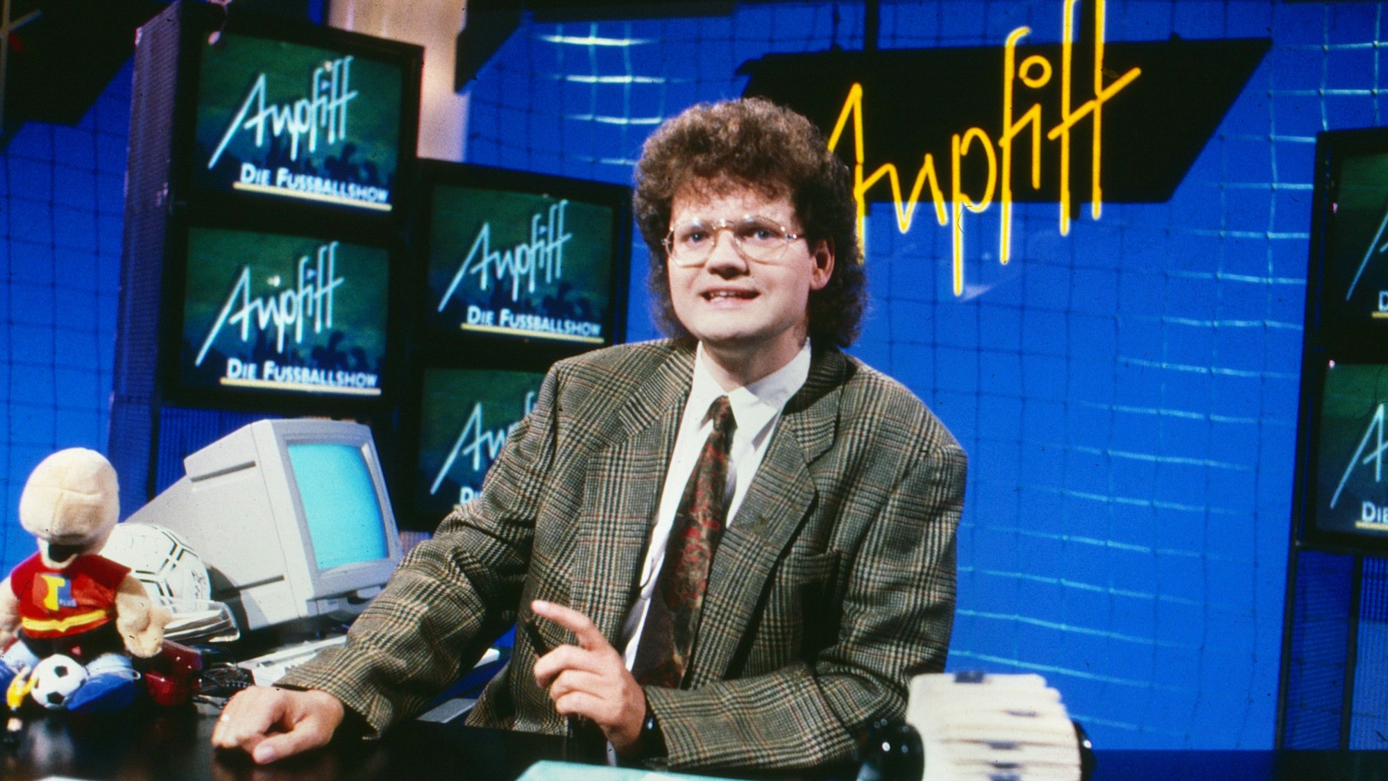 Ulli Potofski sitzt am Schreibtisch der RTL-Sportsendung „Anpfiff“.