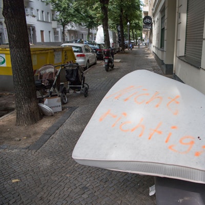 Eine illegal entsorgte Matratze liegt auf einem Gehweg, darauf wurden die Worte „Nicht richtig!!“ gesprüht.