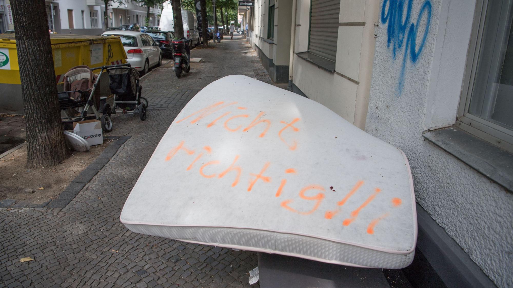Eine illegal entsorgte Matratze liegt auf einem Gehweg, darauf wurden die Worte „Nicht richtig!!“ gesprüht.