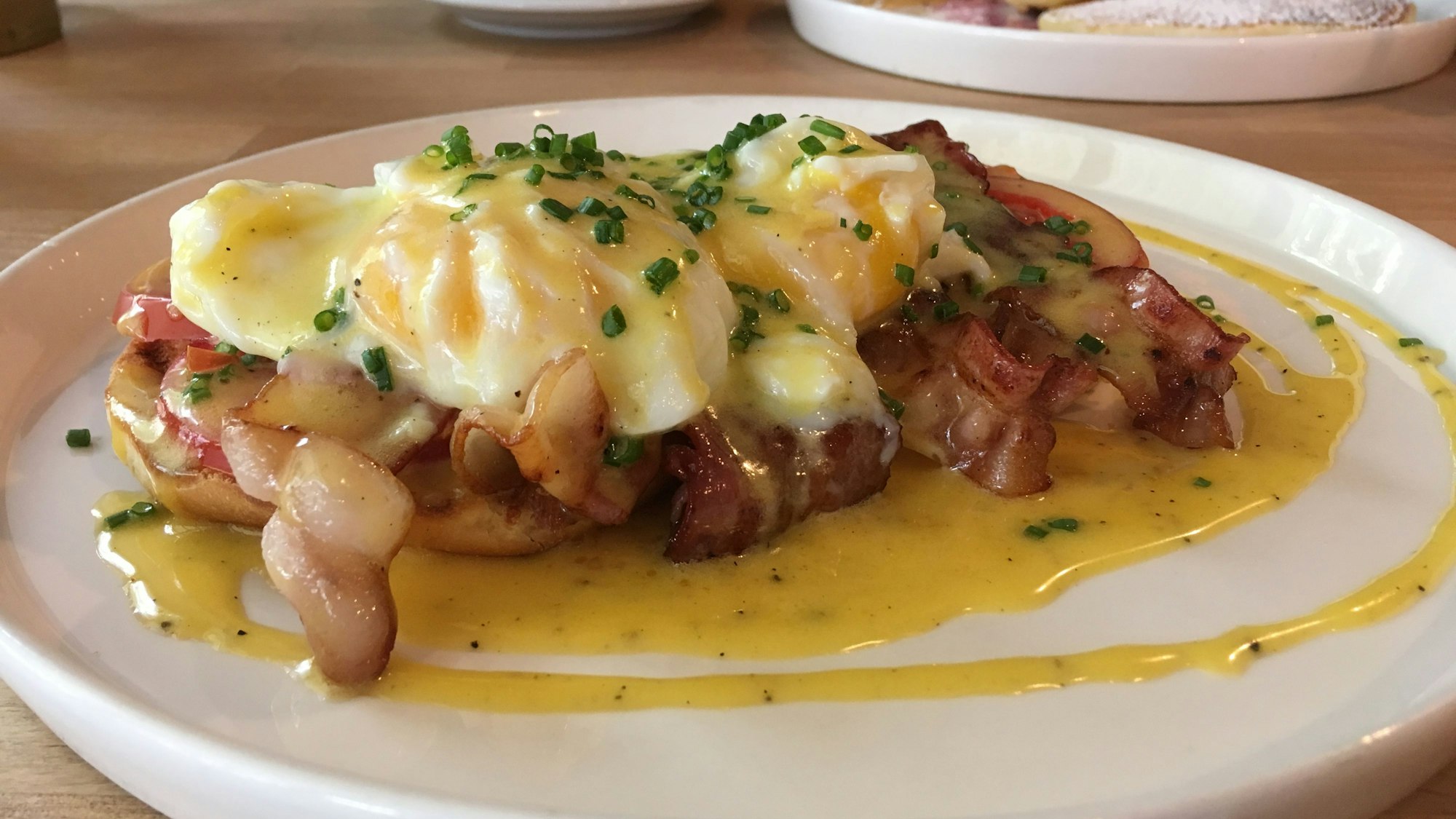 Eggs Benedict im Kölner Café Bo mit Sauce hollandaise und Speck.
