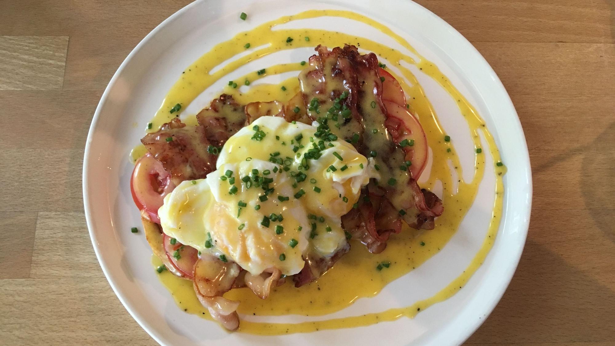 Eggs Benedict auf einem Teller angerichtet.