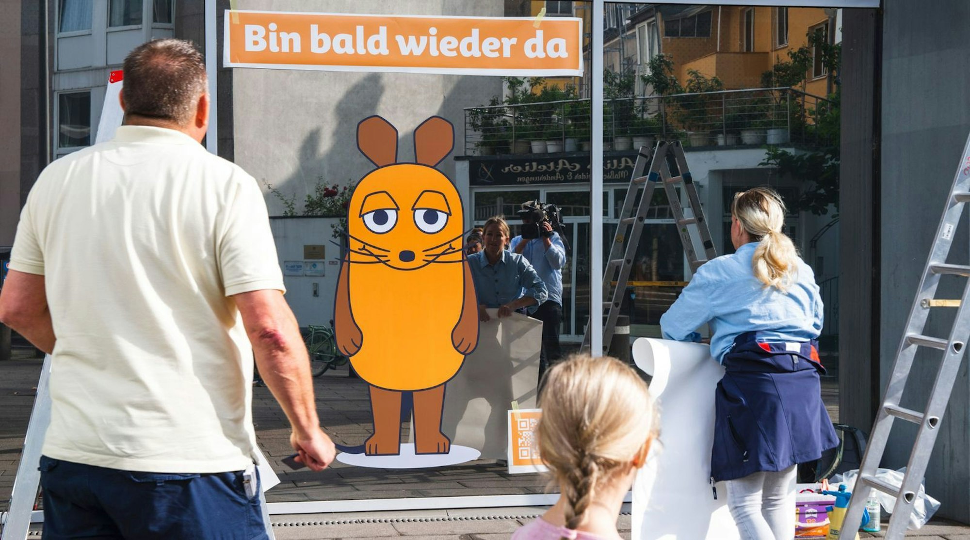 Statt der Maus-Skulptur prangt am Vierscheibenhaus in Köln derzeit ein Aufkleber. (Bild: WDR / Celina Palenda)