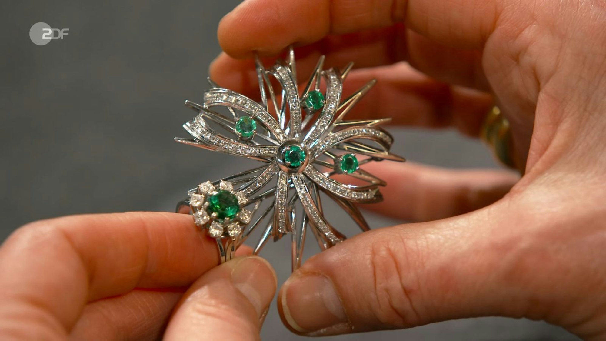 Besetzt mit Smaragden, Diamanten und Turmalin waren Brosche und Ring von Margot. „Frisches Maigras“, so die Assoziaztion der Expertin über die Farbe. „Ich rieche es!“, kommentierte Lichter. Susanne Steiger bezahlte 1.900 Euro. Der Schätzpreis war mit 2.500 Euro höher. (Bild: ZDF)