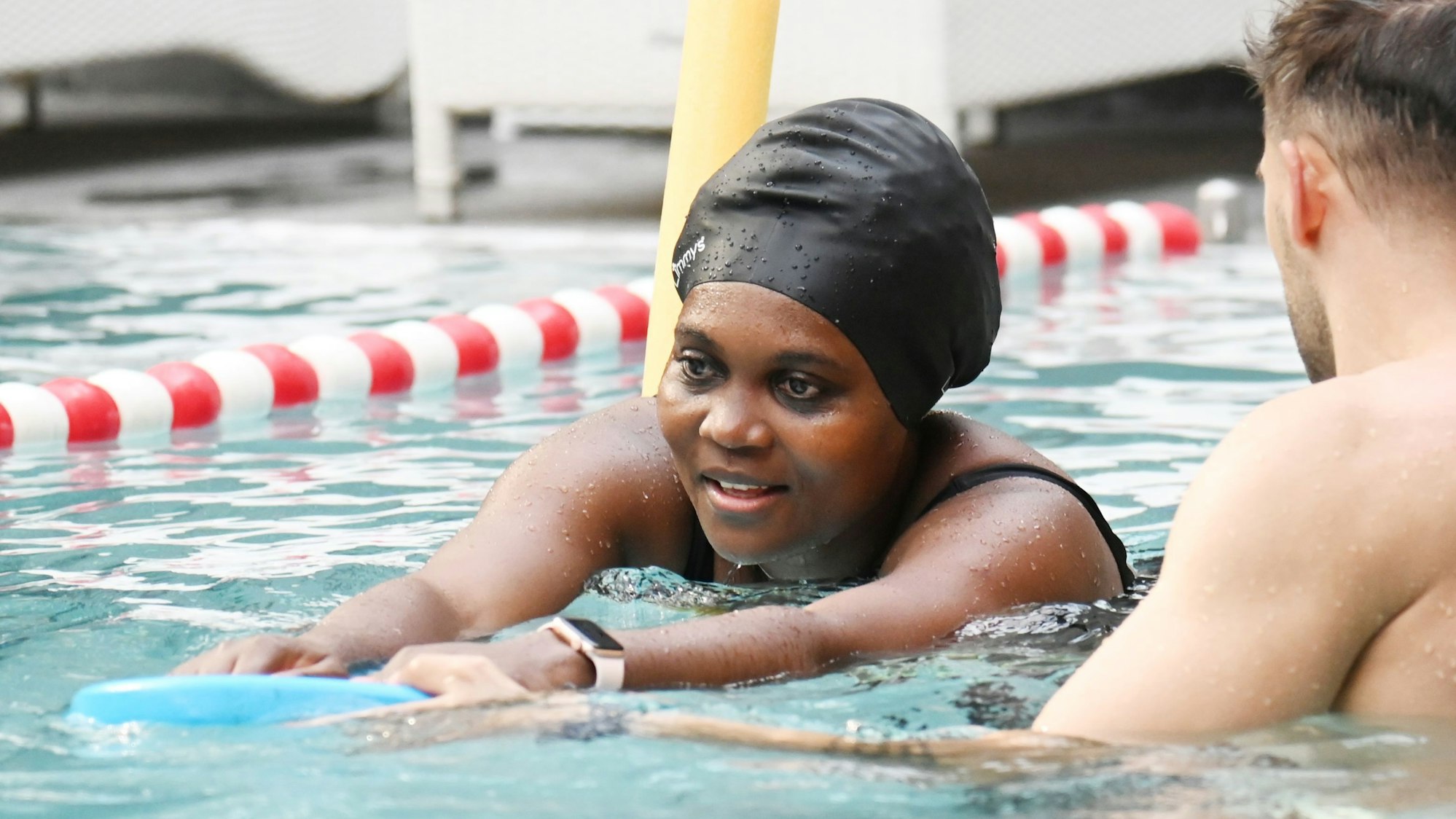 05.08.2025 Köln. Bei der Schwimmschule Otterbuddies lernen auch Erwachsene, wie man sicher und ressourcenschonend schwimmt - das ist besonders in Notlagen wichtig. Wir besuchen eine Einheit. Yannick Hilgers ( mit Shirt ) und Fabian Thorwesten unterrichten Cindy. Foto: Alexander Schwaiger