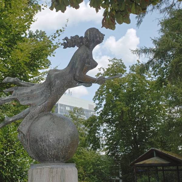 Eine Hexenstatue in einem Park.