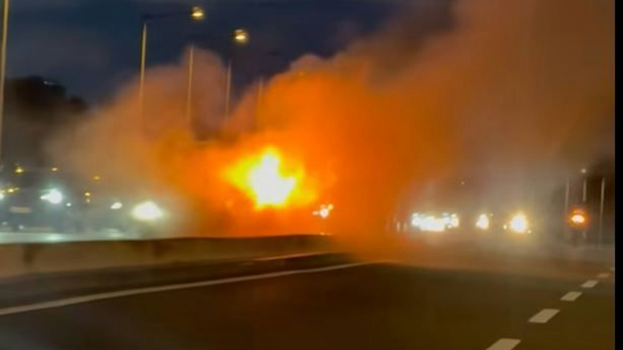 Ein brennender BMW steht auf der Kölner Zoobrücke.