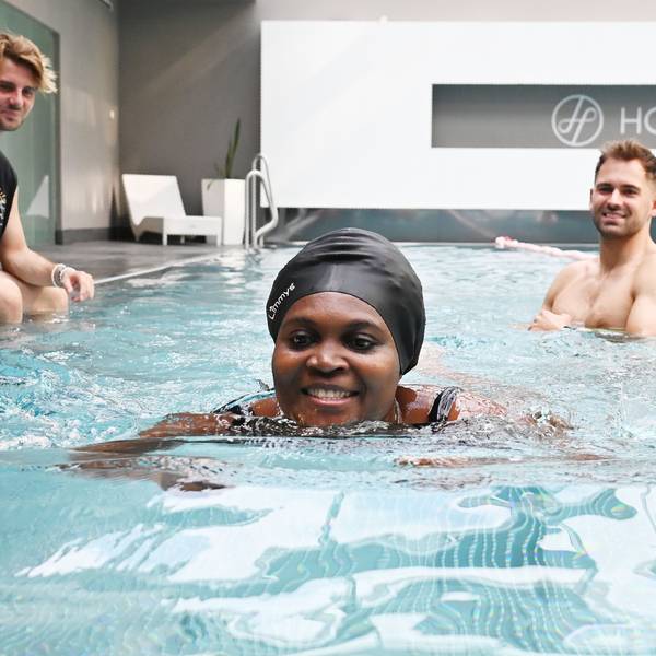 05.08.2025 Köln. Bei der Schwimmschule Otterbuddies lernen auch Erwachsene, wie man sicher und ressourcenschonend schwimmt - das ist besonders in Notlagen wichtig. Wir besuchen eine Einheit. Yannick Hilgers ( mit Shirt ) und Fabian Thorwesten unterrichten Cindy. Foto: Alexander Schwaiger