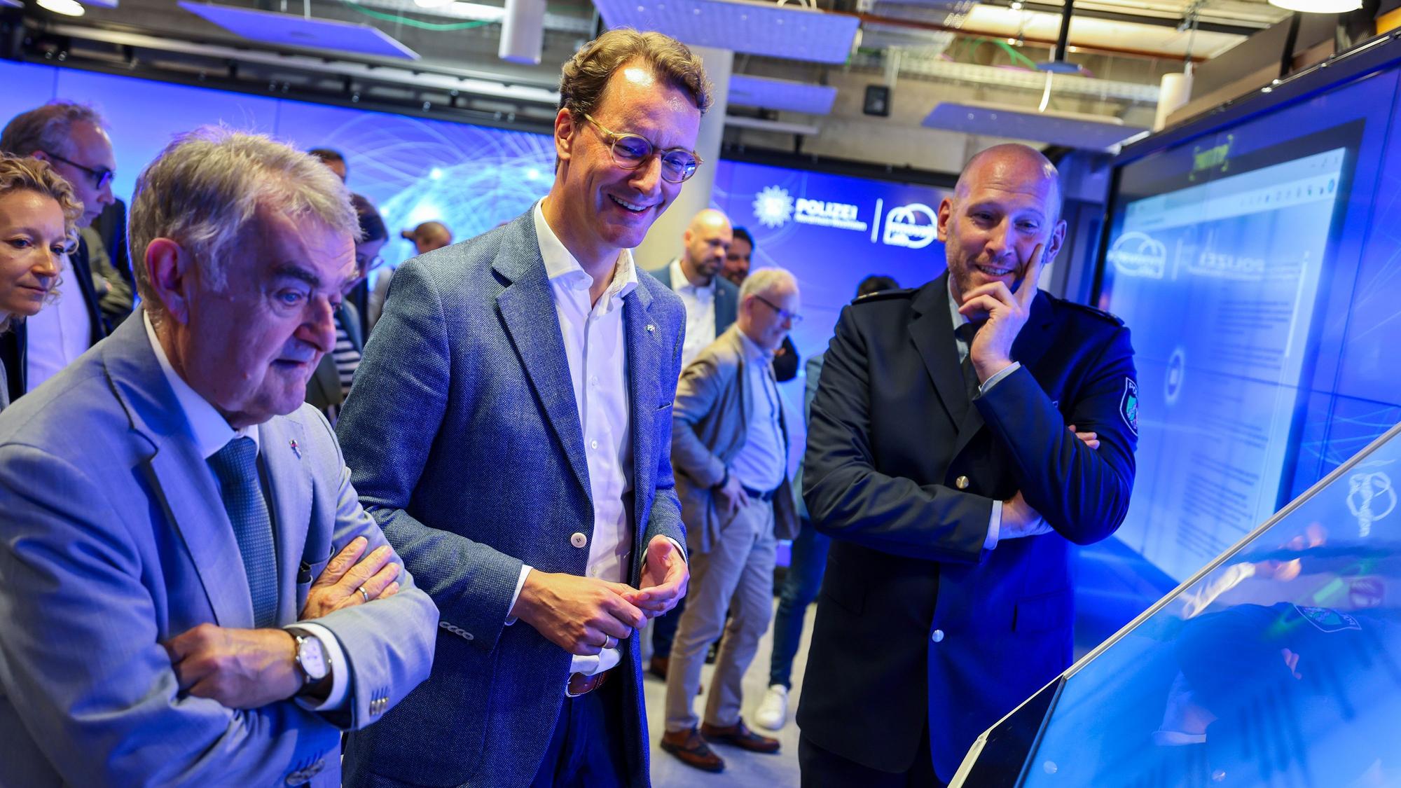 Im „Innovation Lab“ der Polizei NRW benutzen Innenminister Herbert Reul, Ministerpräsident Hendrik Wüst und Dominic Reese, Leiter des Innovation Lab, einen Monitor mit Anwendungen künstlicher Intelligenz. (Archivfoto)