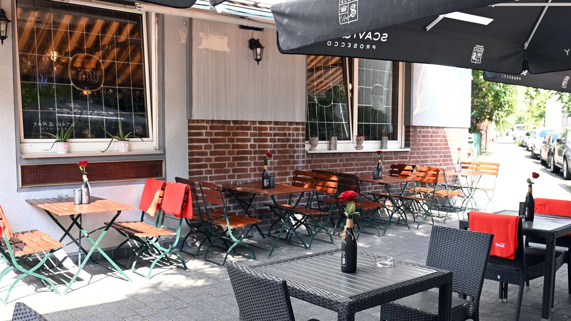 Die bestuhlte Terrasse vor der Hausfassade aus Backstein ist zu sehen.