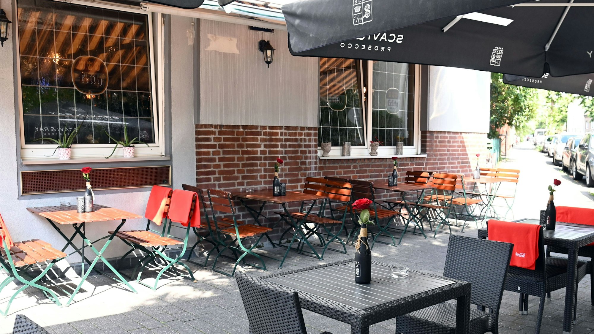 Die bestuhlte Terrasse vor der Hausfassade aus Backstein ist zu sehen.