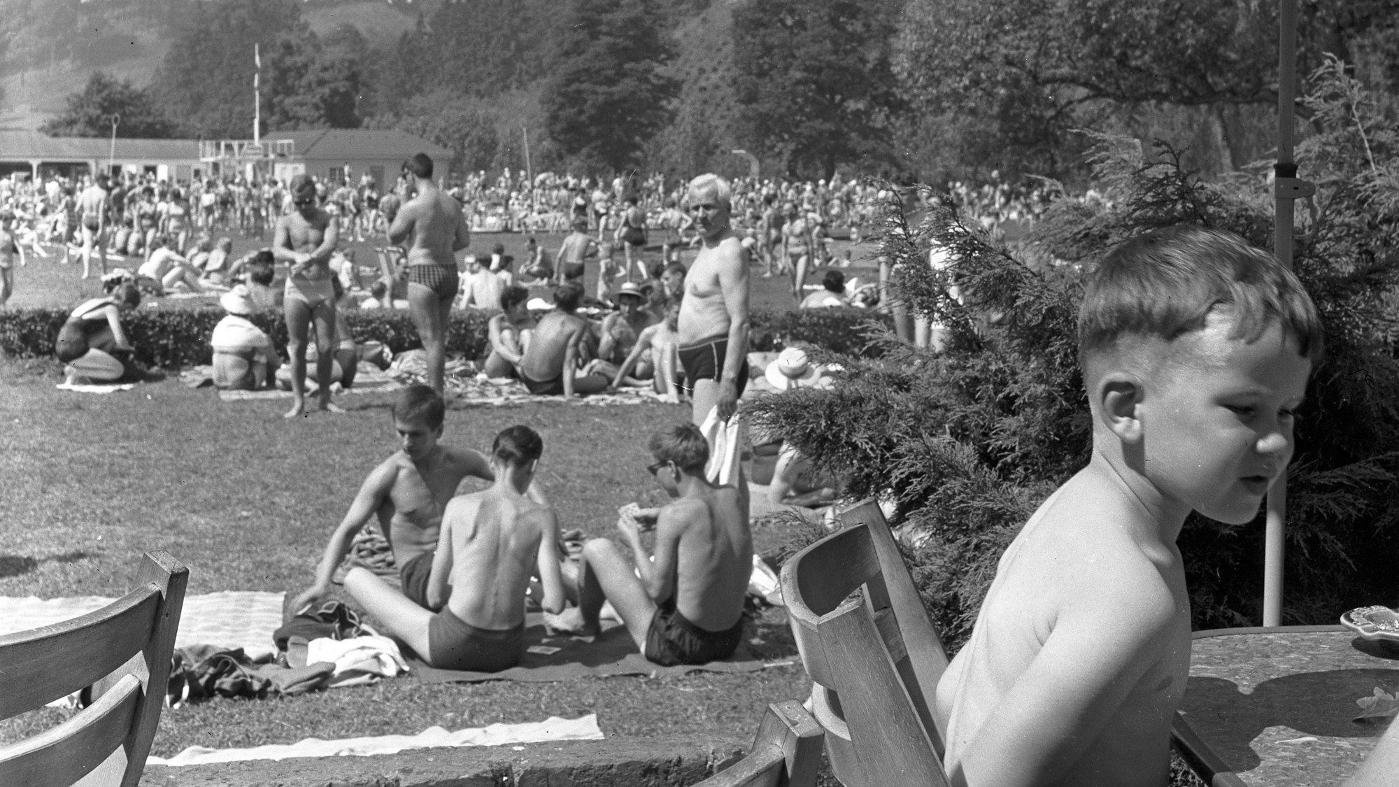 Eine schwarz-weiße Aufnahme des Freibads Herrenstrunden mit vielen Badegästen auf den Wiesen.