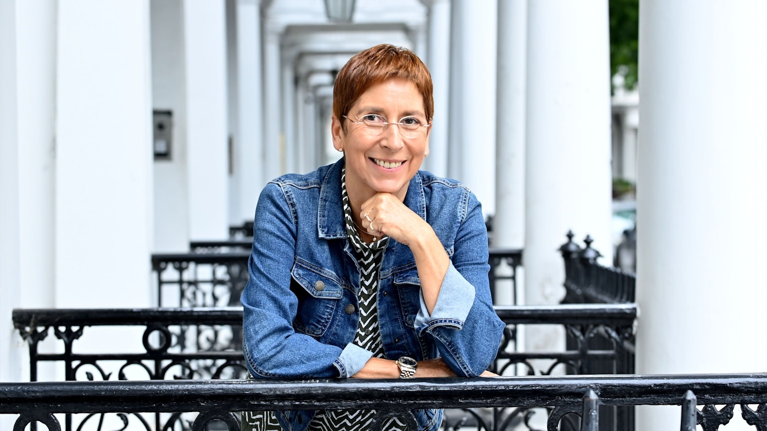 Portrait von Rebecca Gablé in einem Hauseingang in London. Sie lehnt auf einem Treppengeländer.