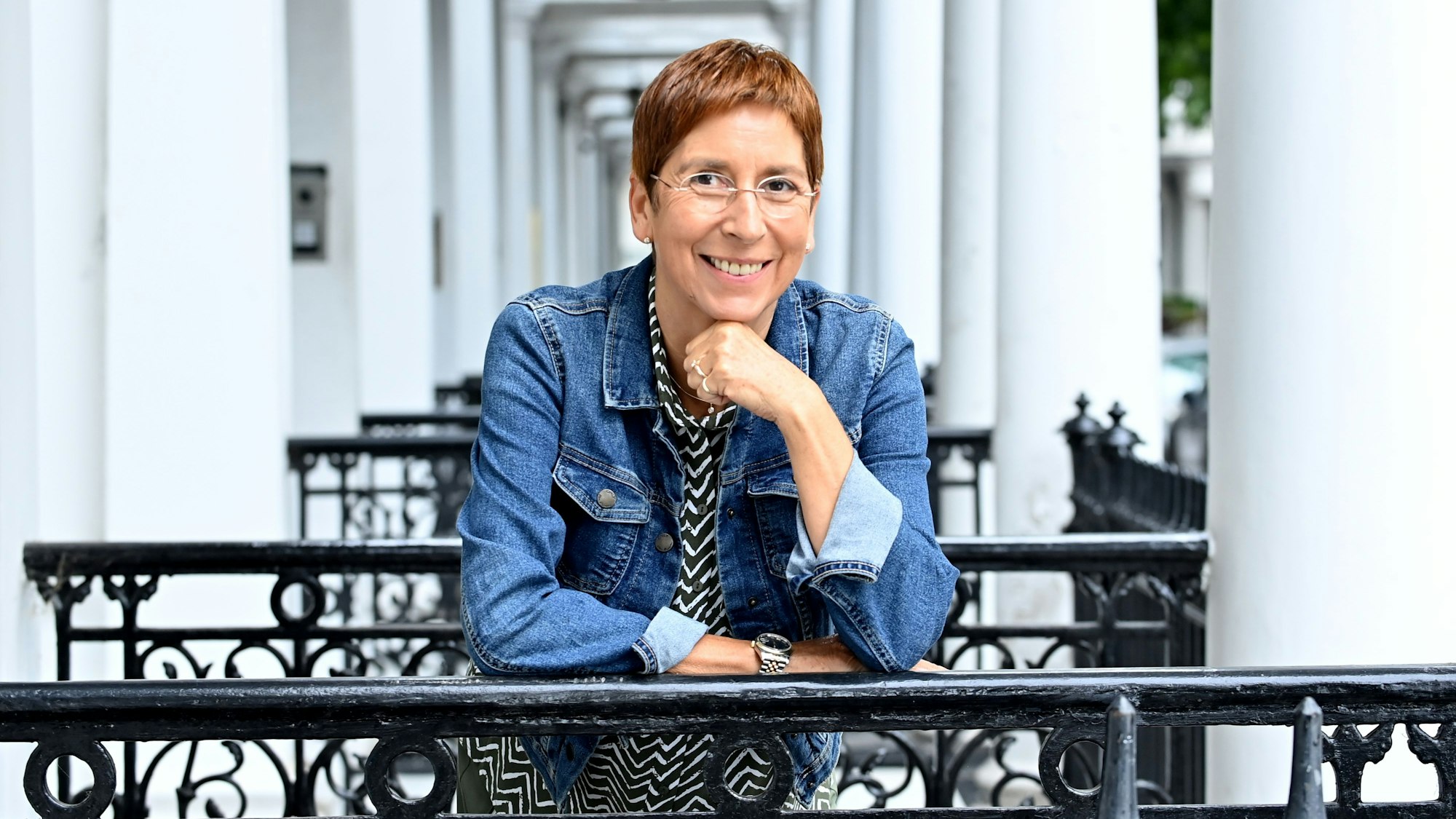 Portrait von Rebecca Gablé in einem Hauseingang in London. Sie lehnt auf einem Treppengeländer.