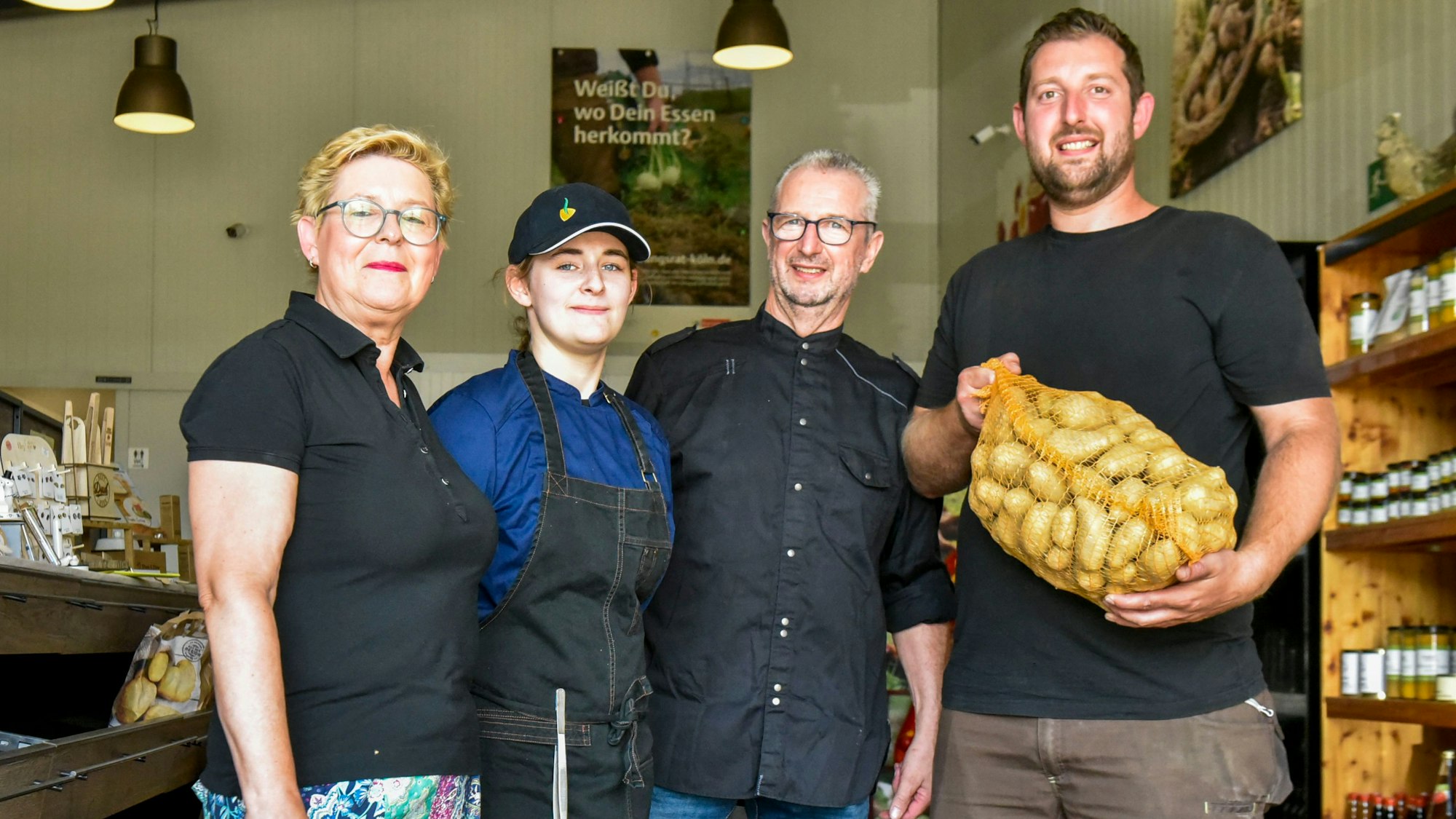 Das Foto zeigt vier Personen, einer hält einen Kartoffelsack in der Hand.