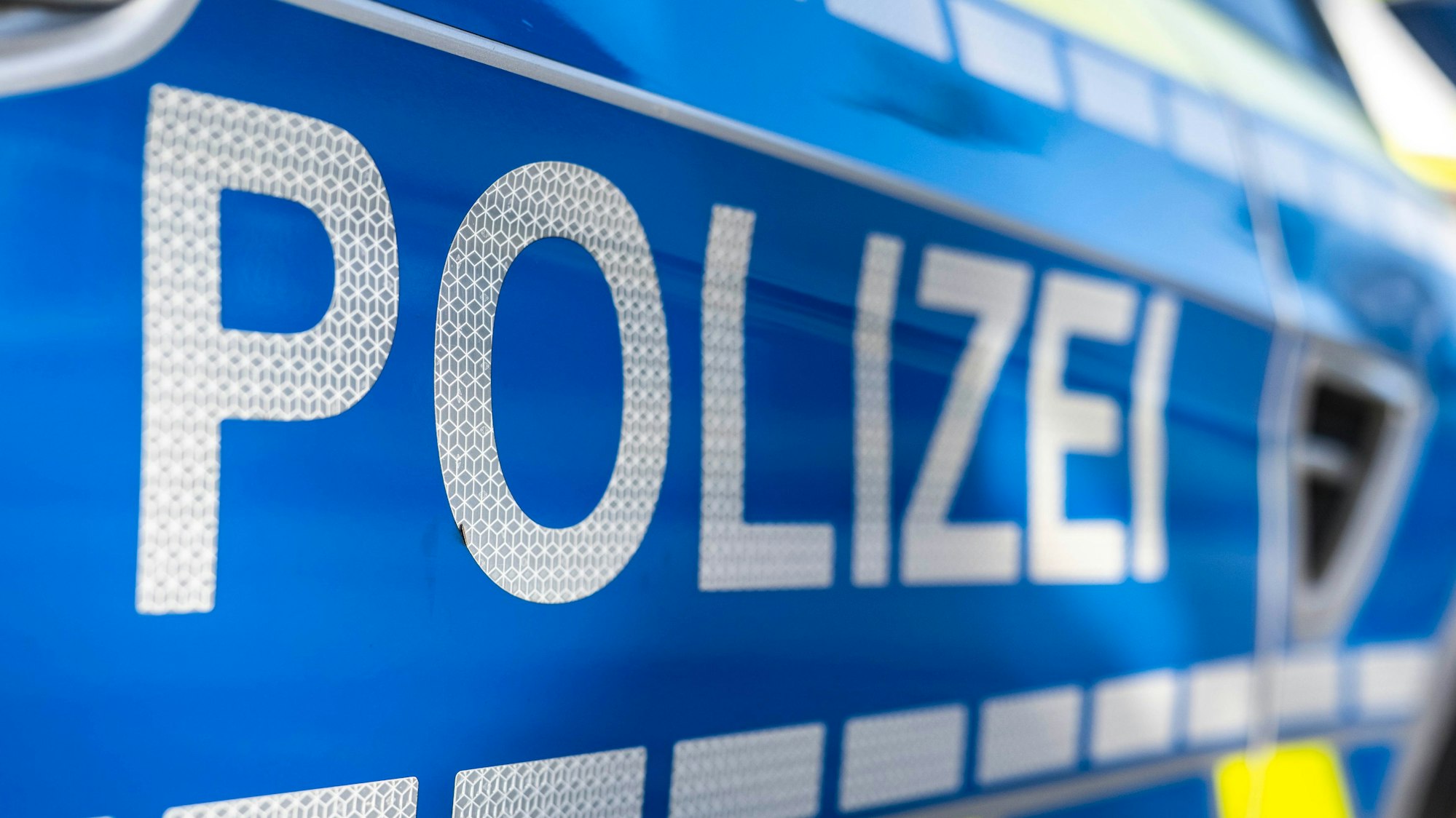 Ein Polizeischriftzug auf einem Polizeiauto.