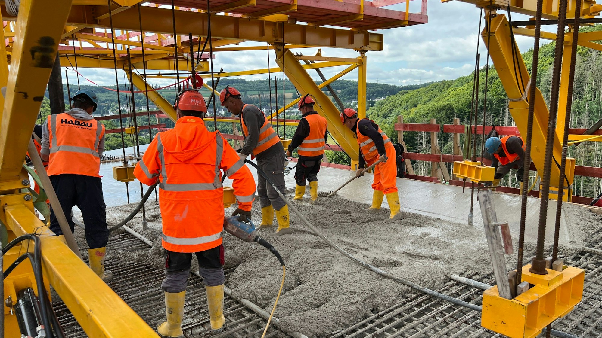 Arbeiter stehen auf der neu errichteten Rahmedetalbrücke bei Lüdenscheid.