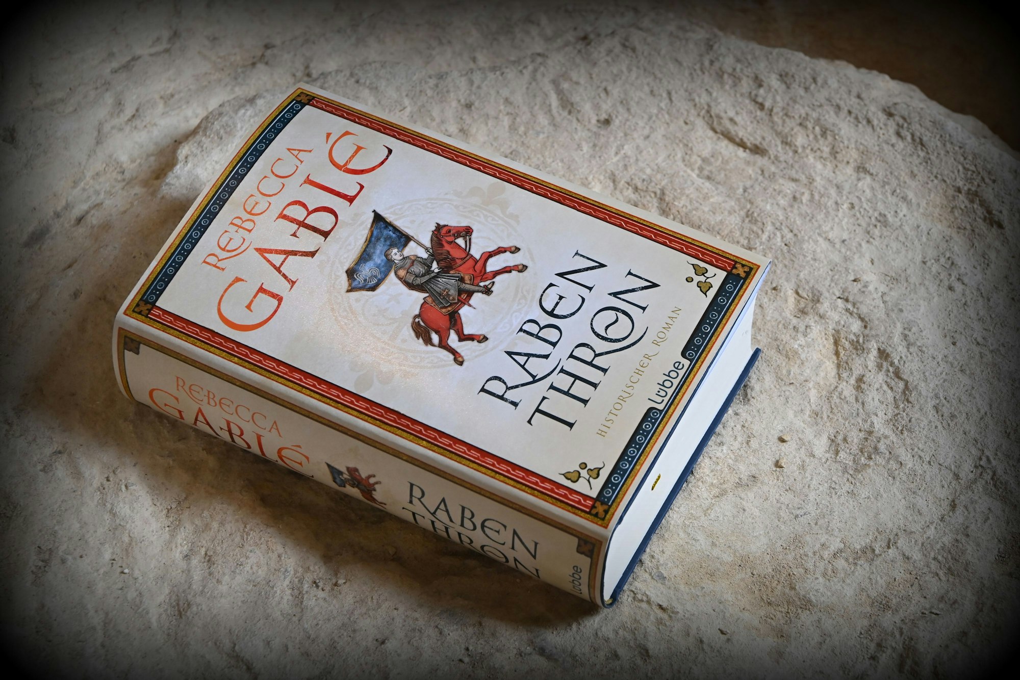 Der neue Roman liegt auf einem Stein, es sind die alten Mauerreste des Oldminsters von Winchester.