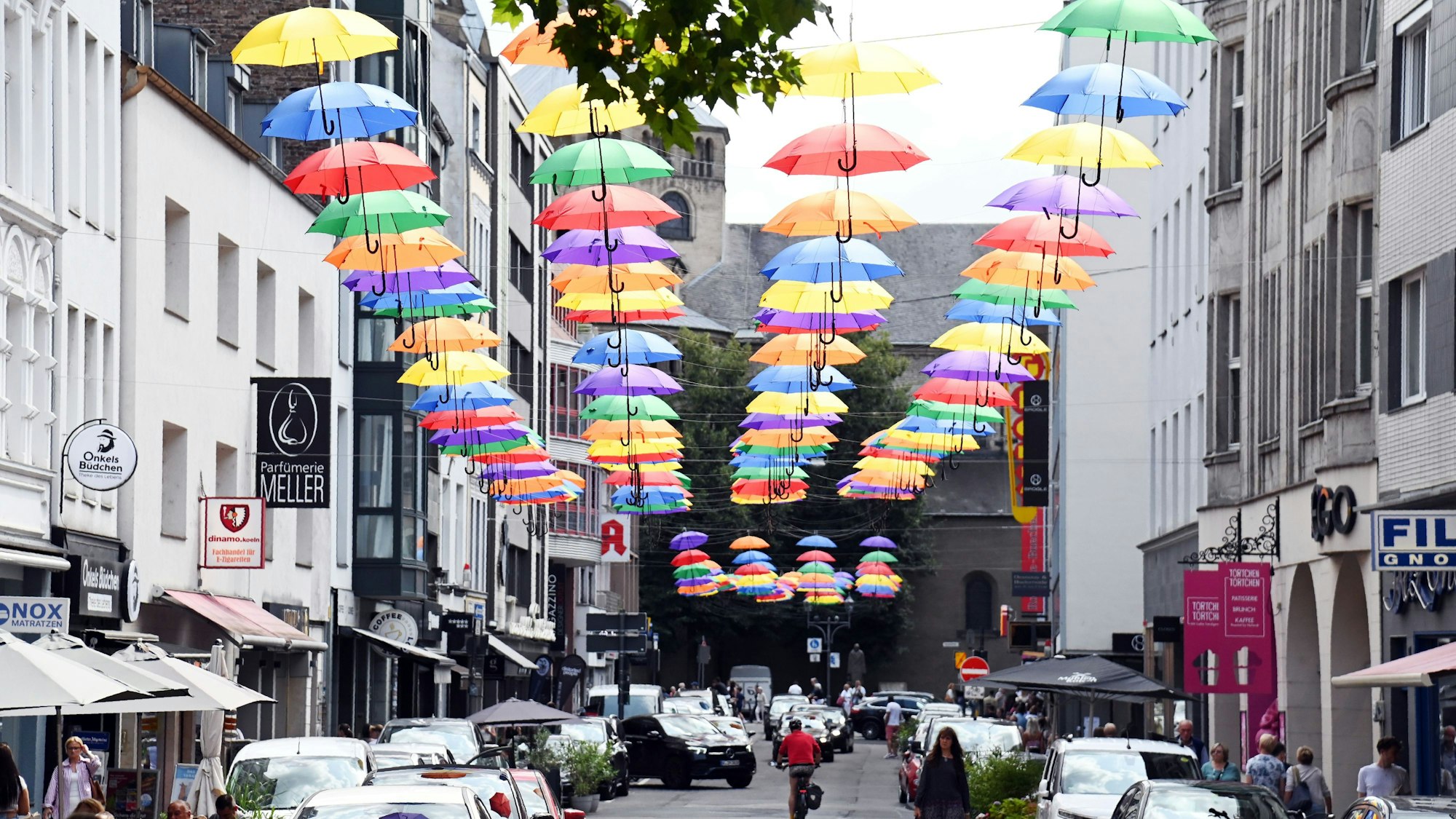 06.08.2025 Köln. Auf der Apostelnstraße hängen viele bunte Regenschirme. Foto: Alexander Schwaiger