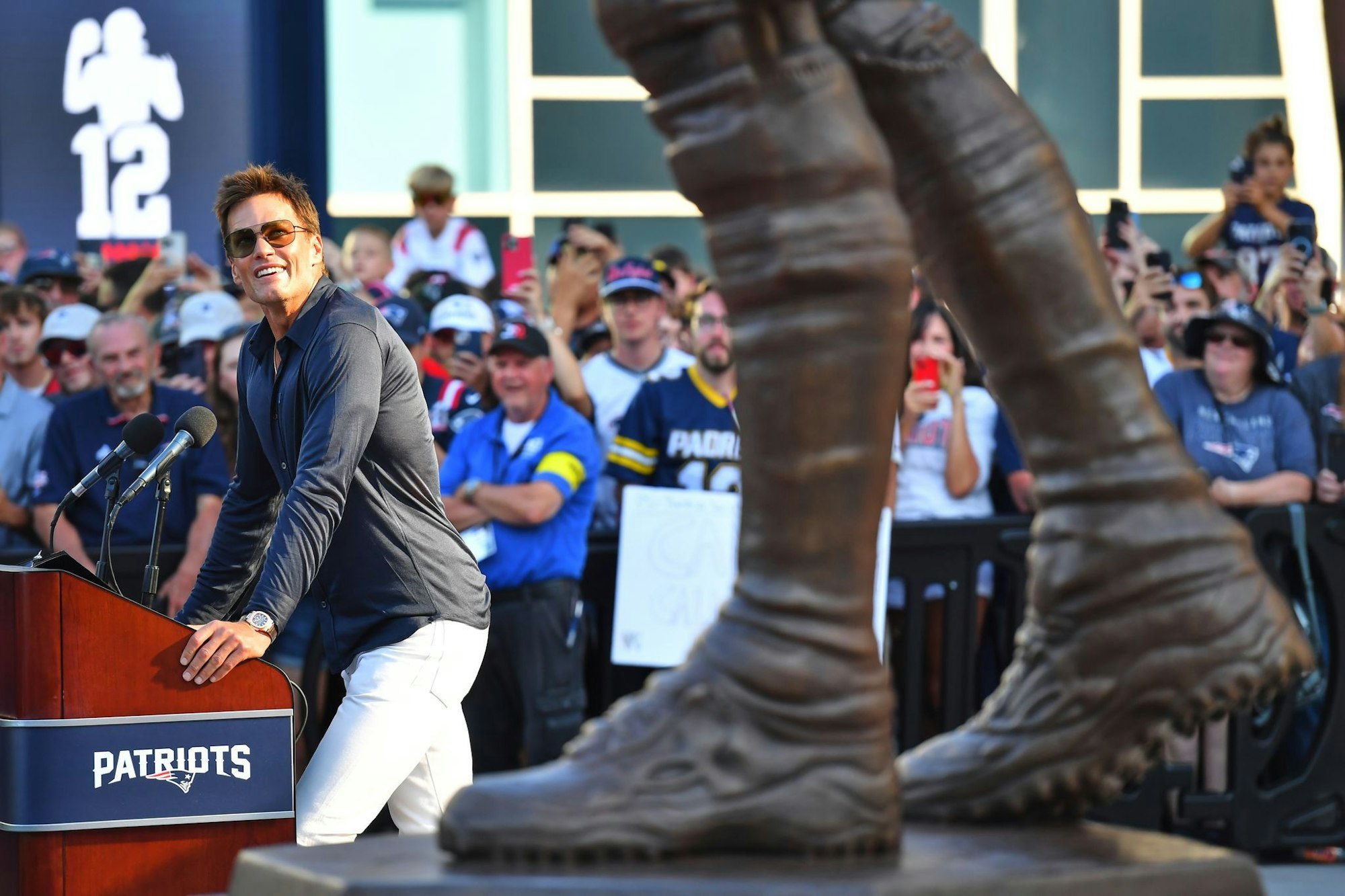 Brady blickt während seiner Rede auf seine frisch enthüllte Bronze-Statue vor dem Stadion der Patriots.