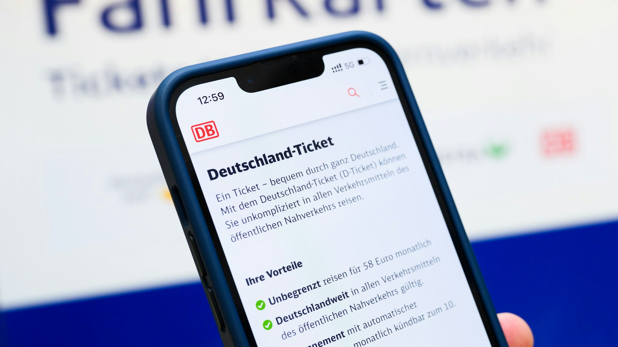 ARCHIV - 12.06.2025, Niedersachsen, Hannover: ILLUSTRATION - Eine Person hält am Hauptbahnhof ein Smartphone in der Hand, auf dessen Display eine Information zum Kauf des Deutschlandtickets zu sehen ist, während sie vor einem Fahrkartenautomaten steht. (zu dpa: «Bayerns Landkreise zweifeln an Zukunft für Deutschlandticket») Foto: Julian Stratenschulte/dpa +++ dpa-Bildfunk +++