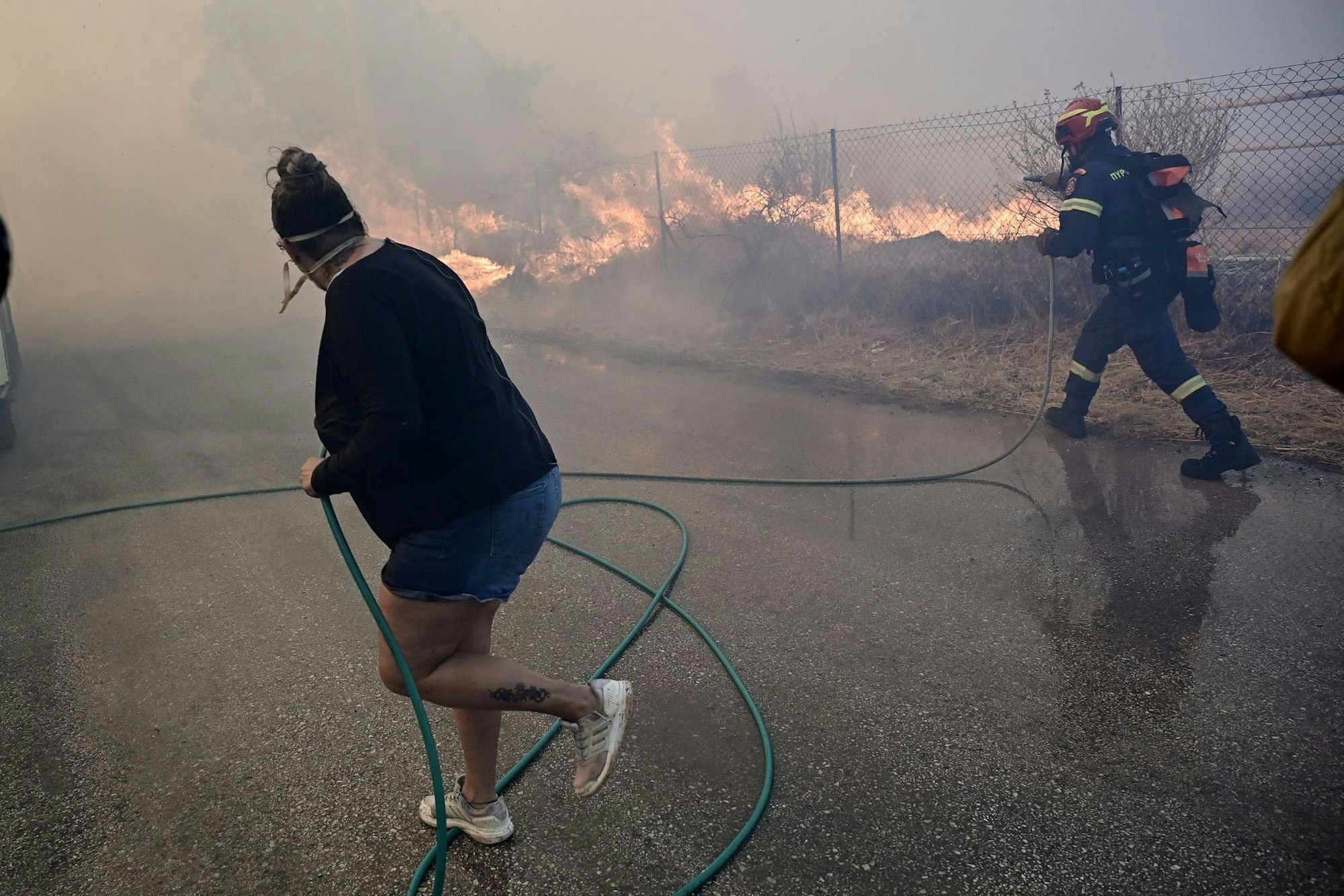 Bewohner und Feuerwehrleute bekämpfen die Flammen.