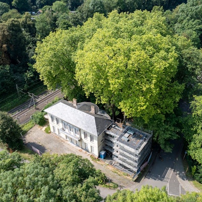 Der Bahnhof Belvedere und der Baum, der dicht am Gebäude wächst, aus der Vogelperspektive.