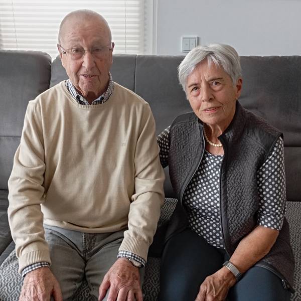 Die beiden sitzen auf einem Sofa. Ingeborg Schulte legt den Arm auf den Rücken ihres Mannes .