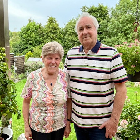 Die beiden Eheleute stehen an ihrem Garten , im Hintergrund ist viel Grün.