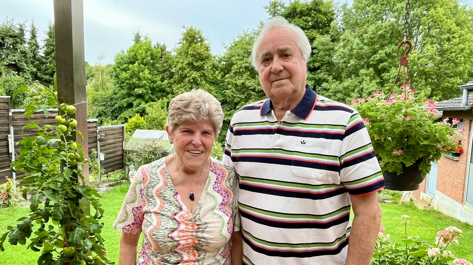 Die beiden Eheleute stehen an ihrem Garten , im Hintergrund ist viel Grün.