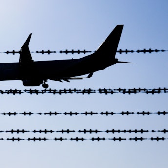 ARCHIV - 17.02.2025, Niedersachsen, Langenhagen: Ein Flugzeug fliegt hinter Stacheldraht am Flughafen Hannover. (zu dpa: «Landkreis weist Kritik an Abschiebung zurück») Foto: Julian Stratenschulte/dpa +++ dpa-Bildfunk +++