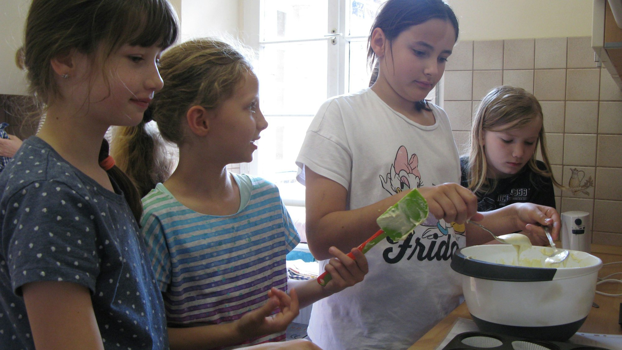 Zusammen füllten Sarah, Miriam, Anna und Armin (v.l.) den Teig in die Muffin-Backform.