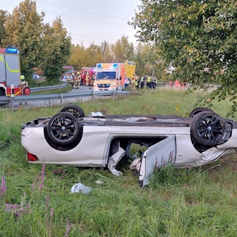 Ein weißes Cabrio liegt auf dem Dach.