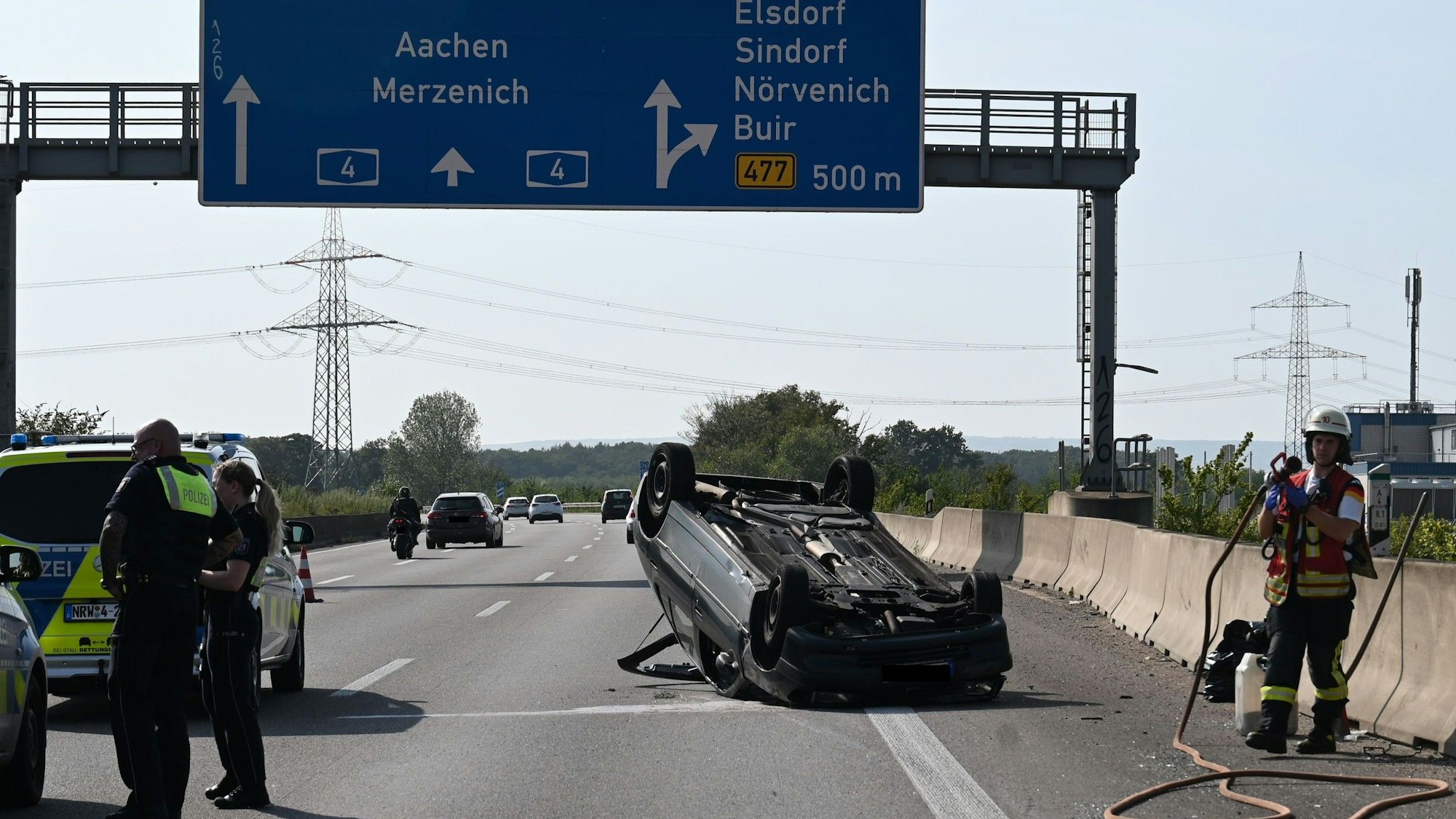 Das Bild zeigt einen auf dem Dach liegenden Kleinwagen auf der Autobahn.